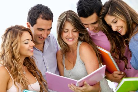 Happy group of young students with a notebook outdoors