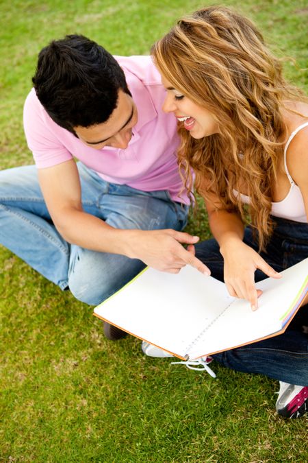 Young couple studying outdoors while having fun