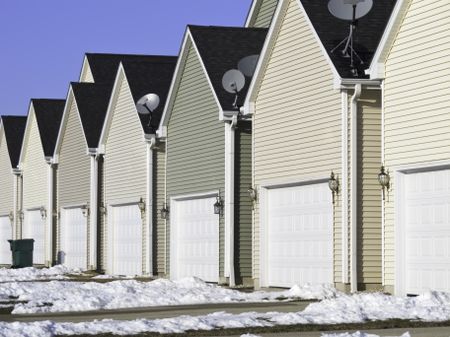 Building conformity: Row of nearly identical one-car garages in winter