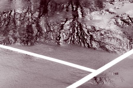 Partial view of tennis court with ice, puddles, and tree reflection