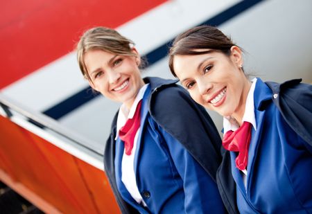 Friendly air hostesses smiling and welcoming into the airplane