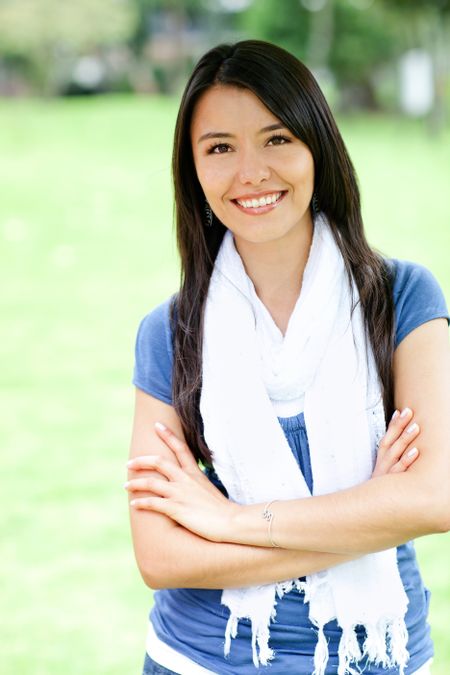 Casual Latin woman outdoors with arms crossed and smiling