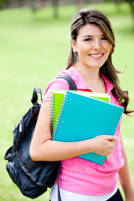 Young female student with notebooks looking happy