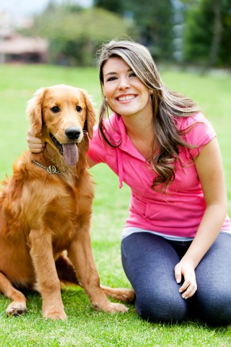 Young woman smiling with a dog at the park