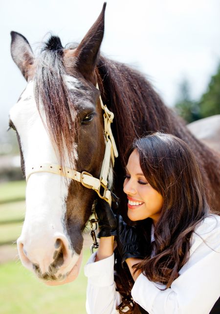 Happy woman with a beautiful horse smiling