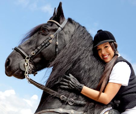 Beautiful woman riding a black horse and smiling