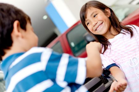 Happy kids playing with car keys at a dealership