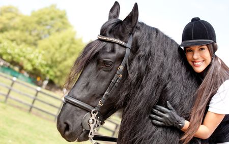 Happy female jockey riding a horse outdoors and smiling