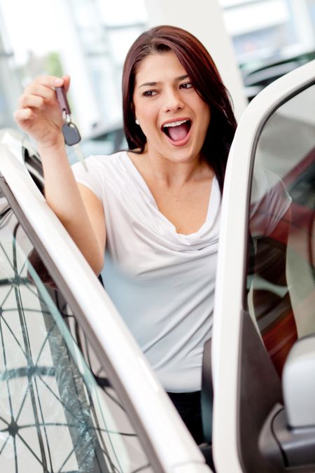 Excited woman buying a car and holding keys