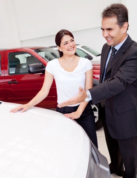 Salesman showing cars to a woman for her to buy