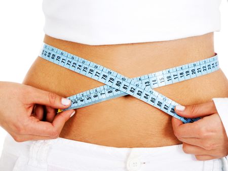 girl measuring her waist checking if she has had any weight loss - isolated over a white background