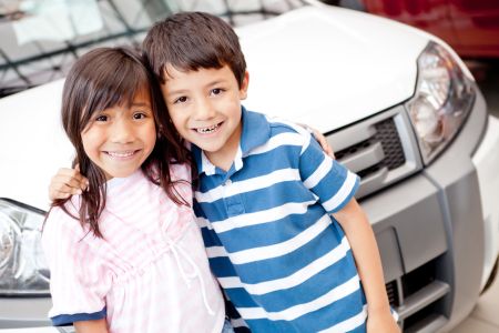 Two kids at the dealer buying a family car