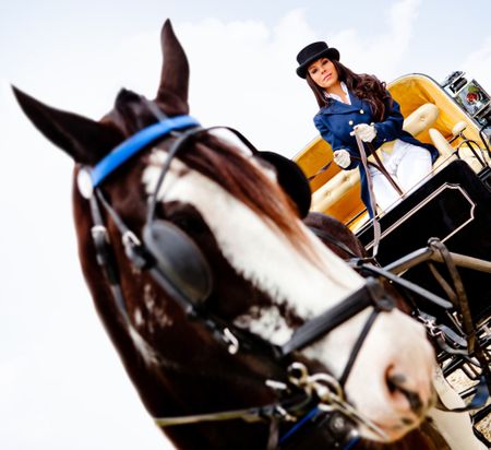 Beautiful woman in an outfit driving a horse carriage
