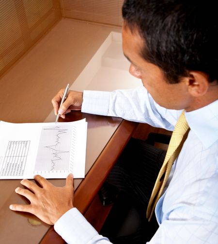 business man writing on a financial report where you can see the company growth