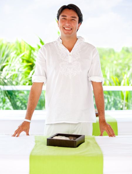 Friendly male masseur at an outdoors spa smiling