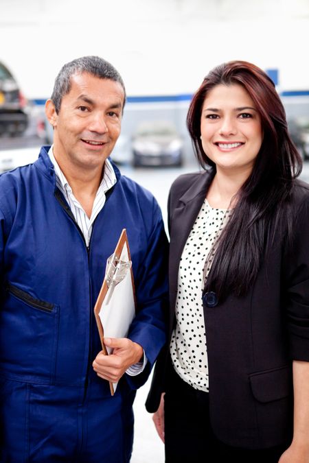 Woman with the mechanic at a car garage