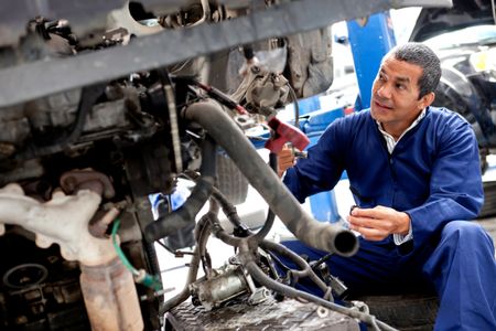 Male mechanic working on a car at a repair shop