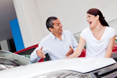 Happy couple looking for a new car at the dealer