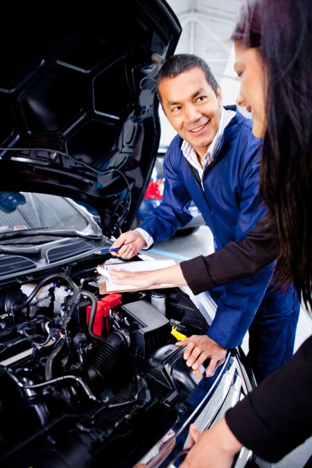 Mechanic explaining to a woman what is the problem with her car