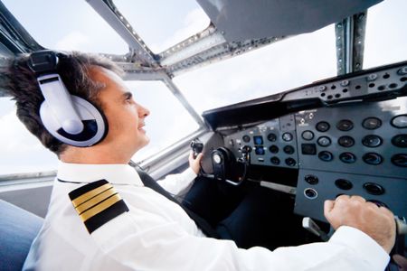 Male pilot sitting in the cabin and flying an airplane