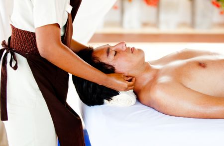 Man relaxing at the spa with a massage on his neck