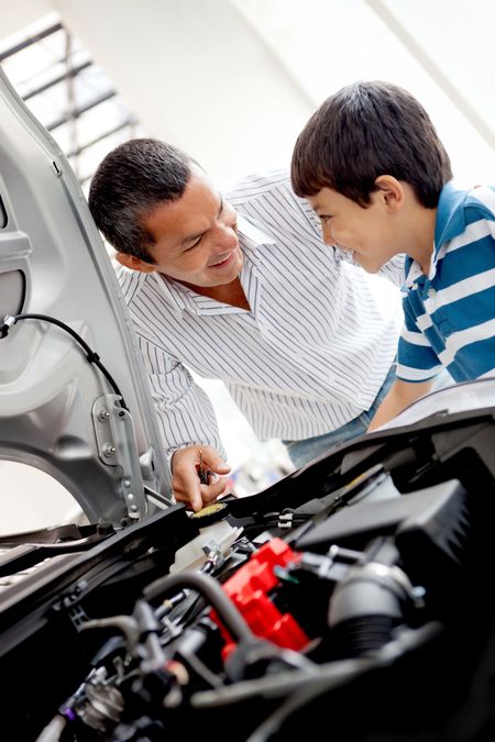 Father and son at the dealer looking at a car engine