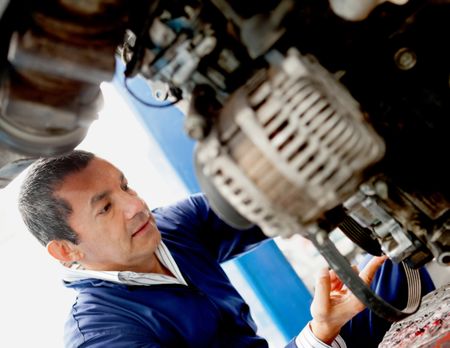 Male mechanic fixing a broken car at the garage