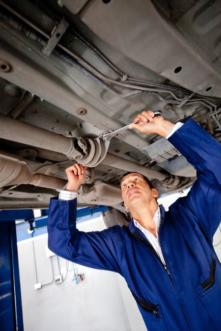 Mechanic working under a car at the garage