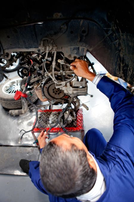Mechanic at the repair shop fixing engine of a car