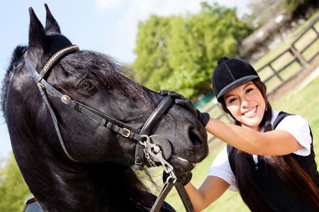 Portrait of a female jockey with a horse outdoors