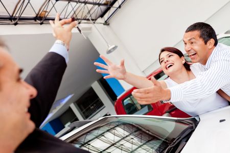 Excited couple buying a car and reaching for the keys