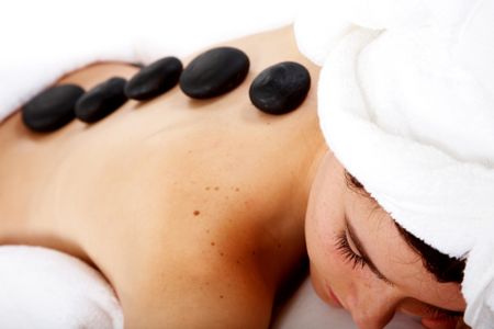 Beauty and Spa concept - girl with volcanic zen stones on her back