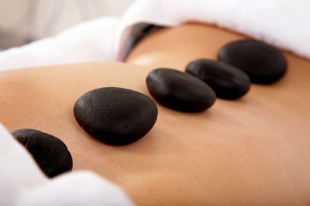 girl in a spa with zen stones on her back