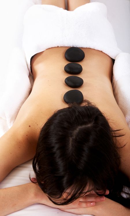 beauty and spa girl with zen stones on her back