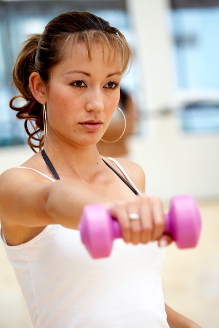 woman doing free weights at the gym in the aerobics room