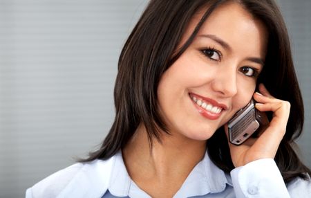business woman on the phone smiling in an office