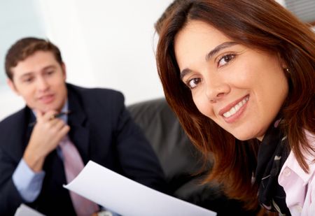 business people in an office with a businesswoman in the foreground smiling