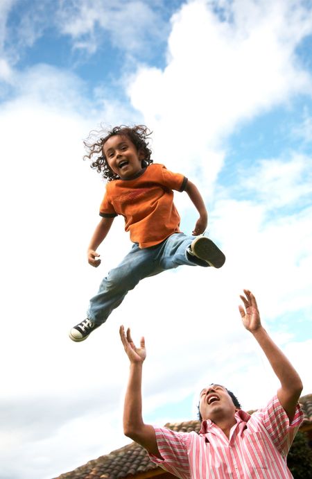 child in the air having fun with his dad