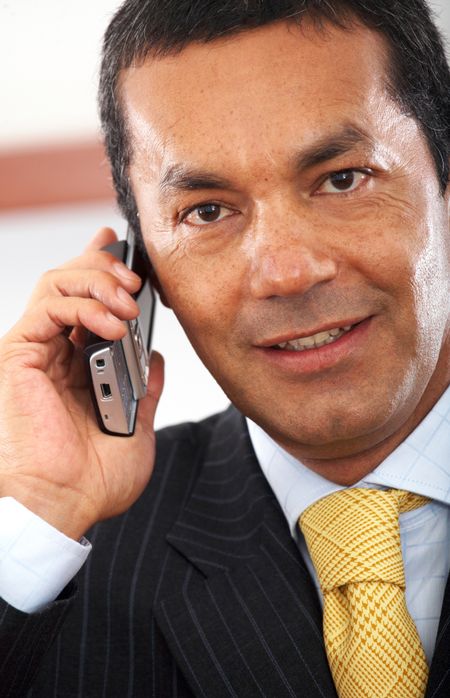 Business man on the phone smiling in his office