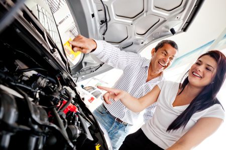 Couple buying a car and checking the engine