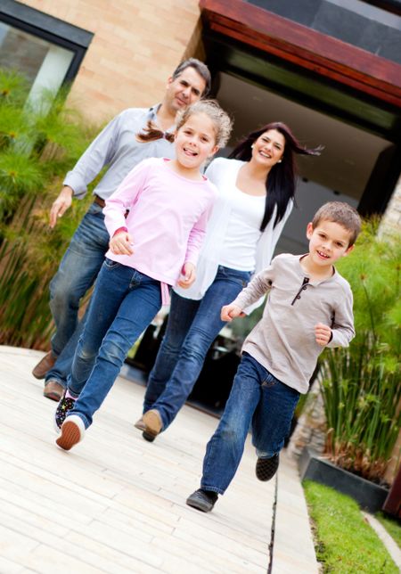 Beautiful family running in front of a house