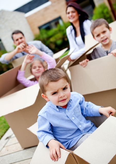Boy in a cardboard box moving house with his family