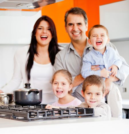 Happy family cooking dinner at home and smiling