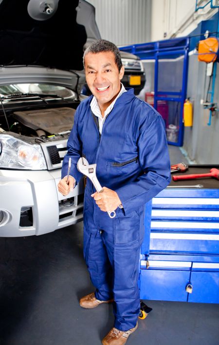 Car mechanic at an auto repair shop holding wrench