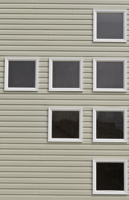 Seven boarded windows with identical white frames on beach house