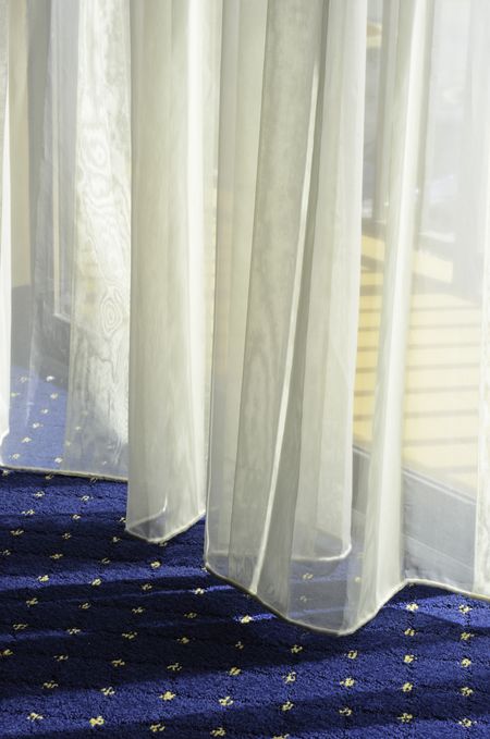 Morning at a glance: Bottom of sheer drapes almost touching carpet by glass door to hotel balcony