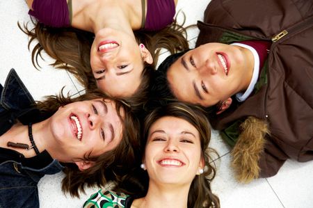 happy group of friends smiling with their heads together on the floor