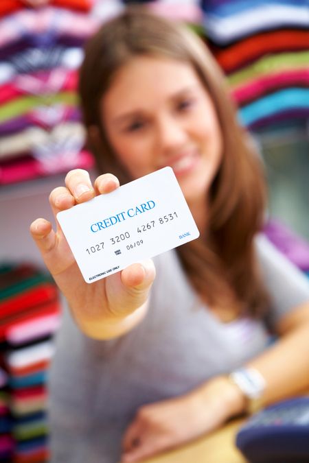 woman holding a credit card in a shop - please note the creditcard numbers are made up