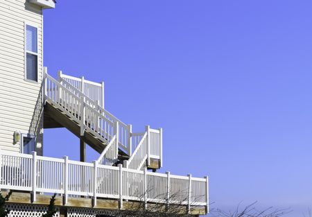 Ocean view, with copy space: White wooden staircase behind beach house overlooking the  Atlantic Ocean
