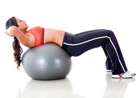 Woman exercising with a  Swiss ball - isolated over a white background